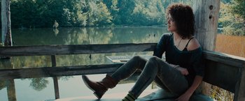 Movie still from “Furious 7” (2015), directed by James Wan – A woman sitting on a bench near a body of water; Medium shot, Low angle