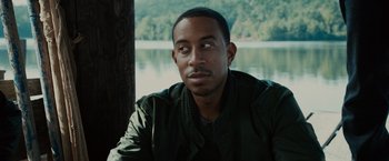 Movie still from “Furious 7” (2015), directed by James Wan – A person sitting near a body of water; Close Up shot, Over the shoulder angle