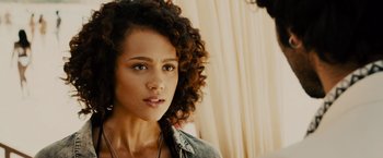 Movie still from “Furious 7” (2015), directed by James Wan – A person with curly brown hair; Close Up shot, Over the shoulder angle