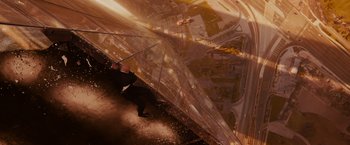 Movie still from “Furious 7” (2015), directed by James Wan – A man holding an umbrella while standing on the side of a building; Extreme Wide shot, Overhead angle