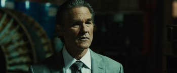 Movie still from “Furious 7” (2015), directed by James Wan – An older man in a suit and tie looking to his left; Close Up shot, Low angle