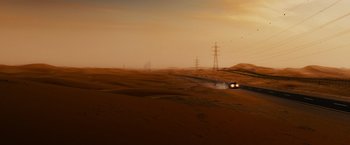 Movie still from “Furious 7” (2015), directed by James Wan – A car driving down a dirt road in the middle of a desert; Extreme Wide shot, High angle