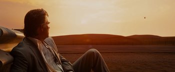 Movie still from “Furious 7” (2015), directed by James Wan – A person sitting on the side of a dirt road; Medium shot, Low angle