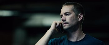 Movie still from “Furious 7” (2015), directed by James Wan – A person talking on a cell phone; Close Up shot, Over the shoulder angle