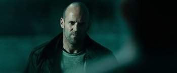 Movie still from “Furious 7” (2015), directed by James Wan – A man with a bald head is looking at the camera; Close Up shot, Over the shoulder angle