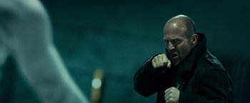 Movie still from “Furious 7” (2015), directed by James Wan – A man with a bald head is holding his fist up; Close Up shot, Low angle