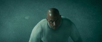 Movie still from “Furious 7” (2015), directed by James Wan – A bald man in a white shirt is looking at the camera; Close Up shot, Low angle