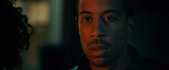 Movie still from “Furious 7” (2015), directed by James Wan – A man's face in a dark room; Close Up shot, Over the shoulder angle