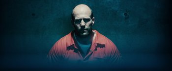 Movie still from “Furious 7” (2015), directed by James Wan – A man with a bald head wearing an orange shirt; Close Up shot, Low angle