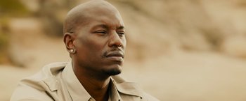 Movie still from “Furious 7” (2015), directed by James Wan – A person wearing a shirt; Close Up shot, Over the shoulder angle