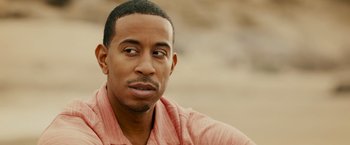 Movie still from “Furious 7” (2015), directed by James Wan – A person wearing a pink shirt; Close Up shot, Over the shoulder angle