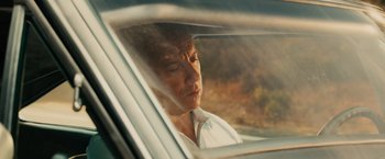 Movie still from “Furious 7” (2015), directed by James Wan – A man sitting in the back seat of a car looking out the window; Close Up shot, Over the shoulder angle
