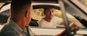 Movie still from “Furious 7” (2015), directed by James Wan – A man sitting in the back seat of a car looking into a mirror; Close Up shot, Over the shoulder angle