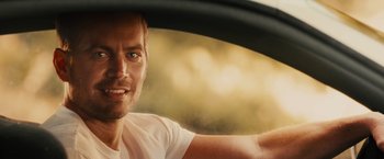 Movie still from “Furious 7” (2015), directed by James Wan – A person driving a car; Close Up shot, Over the shoulder angle