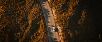 Movie still from “Furious 7” (2015), directed by James Wan – An aerial view of a car driving down a road; Extreme Wide shot, High angle