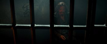 Movie still from “G.I. Joe: The Rise of Cobra” (2009), directed by Stephen Sommers – A man sitting in front of a jail cell; Medium shot, Over the shoulder angle