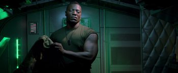 Movie still from “G.I. Joe: The Rise of Cobra” (2009), directed by Stephen Sommers – A man in a green shirt is standing in a room; Medium shot, Low angle