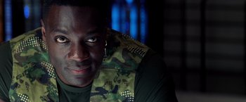 Movie still from “G.I. Joe: The Rise of Cobra” (2009), directed by Stephen Sommers – A person wearing a camouflage vest; Close Up shot, Over the shoulder angle