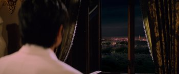 Movie still from “G.I. Joe: The Rise of Cobra” (2009), directed by Stephen Sommers – A woman looking out a window at night; Medium shot, Over the shoulder angle
