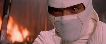 Movie still from “G.I. Joe: The Rise of Cobra” (2009), directed by Stephen Sommers – A man wearing a white mask and a white suit; Close Up shot, Low angle