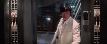 Movie still from “G.I. Joe: The Rise of Cobra” (2009), directed by Stephen Sommers – A man in a white suit standing next to a building; Medium shot, Low angle