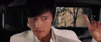 Movie still from “G.I. Joe: The Rise of Cobra” (2009), directed by Stephen Sommers – A person wearing a suit in a car; Close Up shot, Over the shoulder angle