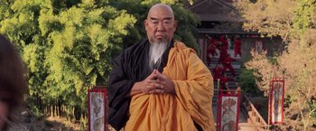 Movie still from “G.I. Joe: The Rise of Cobra” (2009), directed by Stephen Sommers – An older man with a long beard wearing an orange and black robe; Medium shot, Low angle