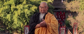 Movie still from “G.I. Joe: The Rise of Cobra” (2009), directed by Stephen Sommers – An old man with a long white beard wearing an orange and black robe; Medium shot, Low angle