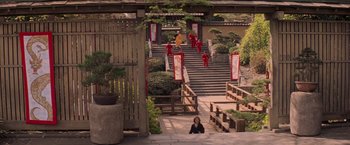 Movie still from “G.I. Joe: The Rise of Cobra” (2009), directed by Stephen Sommers – A woman sitting on steps in front of a building; Extreme Wide shot, High angle