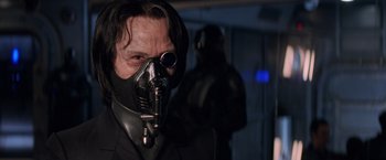 Movie still from “G.I. Joe: The Rise of Cobra” (2009), directed by Stephen Sommers – A man wearing a suit and a gas mask; Close Up shot, Low angle