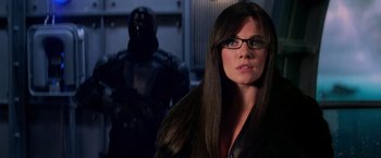 Movie still from “G.I. Joe: The Rise of Cobra” (2009), directed by Stephen Sommers – A woman in glasses and a leather jacket looking at the camera; Close Up shot, Over the shoulder angle