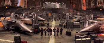Movie still from “G.I. Joe: The Rise of Cobra” (2009), directed by Stephen Sommers – A group of people walking across a runway in a hangar; Extreme Wide shot, High angle