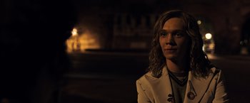 Movie still from “All the Money in the World” (2017), directed by Ridley Scott – A man with long hair is standing in the dark; Close Up shot, Over the shoulder angle