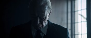 Movie still from “All the Money in the World” (2017), directed by Ridley Scott – An older man in a suit and tie looking down; Close Up shot, Low angle