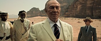 Movie still from “All the Money in the World” (2017), directed by Ridley Scott – An older man in a suit and tie in front of a desert landscape; Medium shot, Over the shoulder angle