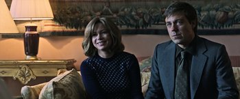 Movie still from “All the Money in the World” (2017), directed by Ridley Scott – A woman sitting next to a man on a couch; Medium shot, Over the shoulder angle