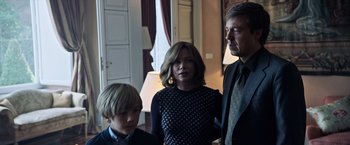 Movie still from “All the Money in the World” (2017), directed by Ridley Scott – A man and two women and a boy standing in a room; Medium shot, Over the shoulder angle