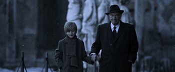 Movie still from “All the Money in the World” (2017), directed by Ridley Scott – An older man and a young boy holding hands; Medium shot, Over the shoulder angle