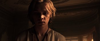 Movie still from “All the Money in the World” (2017), directed by Ridley Scott – A man with long blonde hair wearing a white shirt; Close Up shot, Low angle