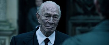 Movie still from “All the Money in the World” (2017), directed by Ridley Scott – An older man in a suit and tie; Close Up shot, Over the shoulder angle