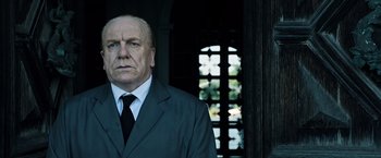 Movie still from “All the Money in the World” (2017), directed by Ridley Scott – An older man wearing a suit and tie; Close Up shot, Low angle