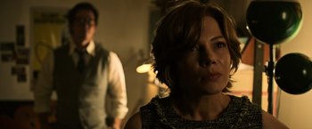 Movie still from “All the Money in the World” (2017), directed by Ridley Scott – A man and a woman standing next to each other in a dark room; Close Up shot, Over the shoulder angle