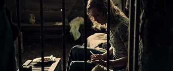 Movie still from “All the Money in the World” (2017), directed by Ridley Scott – A woman sitting on a bed looking at her cell phone; Medium shot, High angle