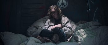 Movie still from “All the Money in the World” (2017), directed by Ridley Scott – A person sitting on a bed with a blanket; Medium shot, Low angle