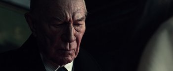 Movie still from “All the Money in the World” (2017), directed by Ridley Scott – An older man wearing a suit and tie with his eyes wide open; Close Up shot, Low angle