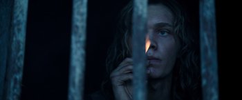 Movie still from “All the Money in the World” (2017), directed by Ridley Scott – A woman is looking through a fence at night; Close Up shot, Low angle