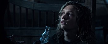 Movie still from “All the Money in the World” (2017), directed by Ridley Scott – A person holding a bottle of water in a dark room; Close Up shot, High angle