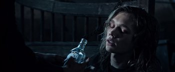 Movie still from “All the Money in the World” (2017), directed by Ridley Scott – A person holding a bottle of alcohol in their hand; Close Up shot, High angle