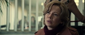 Movie still from “All the Money in the World” (2017), directed by Ridley Scott – A person with short hair wearing a jacket; Close Up shot, Over the shoulder angle