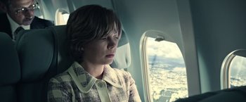 Movie still from “All the Money in the World” (2017), directed by Ridley Scott – A woman looking out a window of an airplane; Close Up shot, High angle